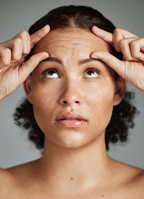 Visage D une femme posant les mains sur le front Rides du front | Dr Khalifa Montauban